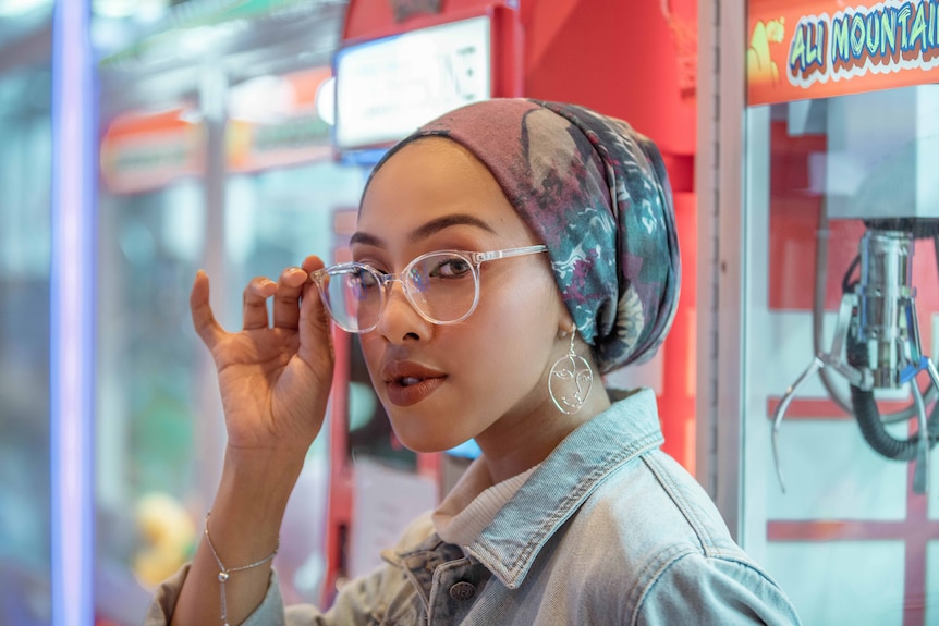 Woman with a head scarf wearing clear plastic framed glasses