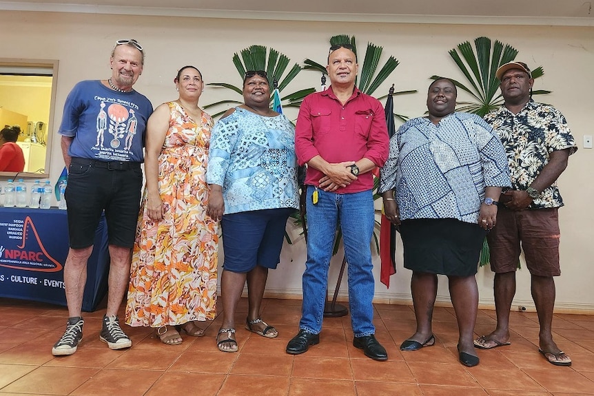 White man standing next to two Indigenous women and three Indigenous men