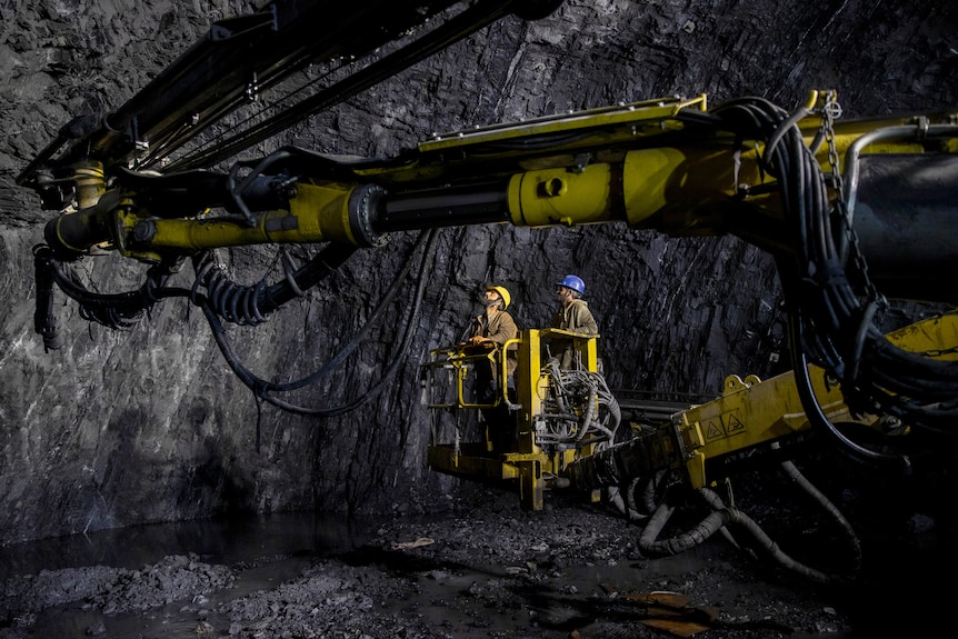 Construction workers dressed in yellow work underground