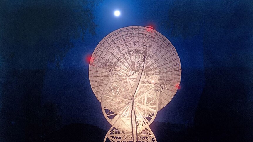 Photo of the The Honeysuckle Creek relay station at night, pointing at the Moon.