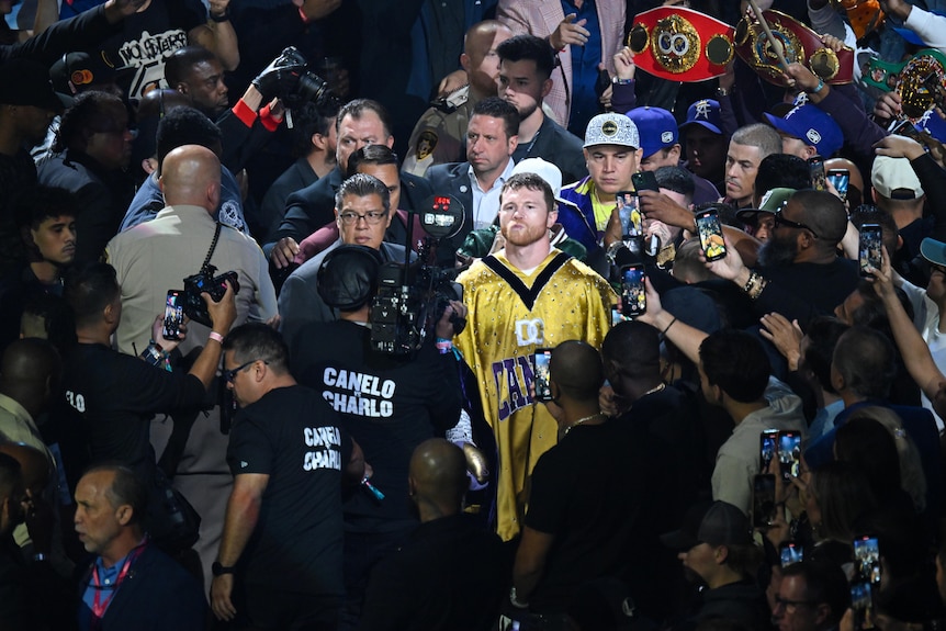 Canelo walks to the ring surrounded by people