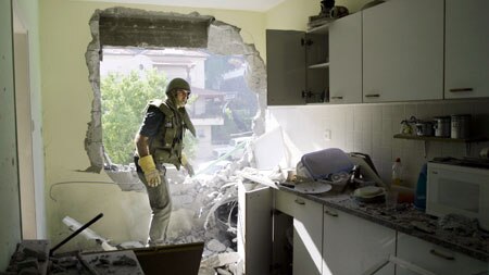 An Israeli rescue worker surveys the scene of a rocket attack in an northern Israeli city.