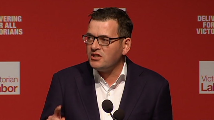 Daniel Andrews speaks at a lectern in front of a backdrop bearing the ALP logo.