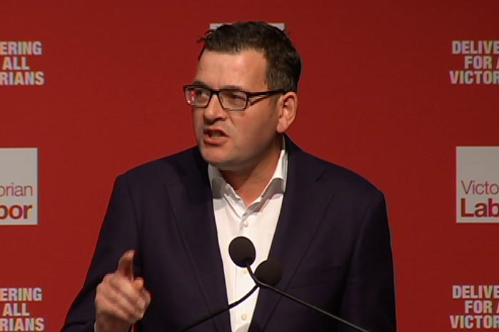 Daniel Andrews speaks at a lectern in front of a backdrop bearing the ALP logo.