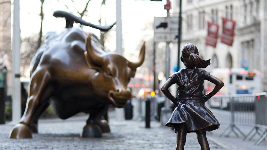 The Fearless Girl statue faces the Charging Bull statue in New York.