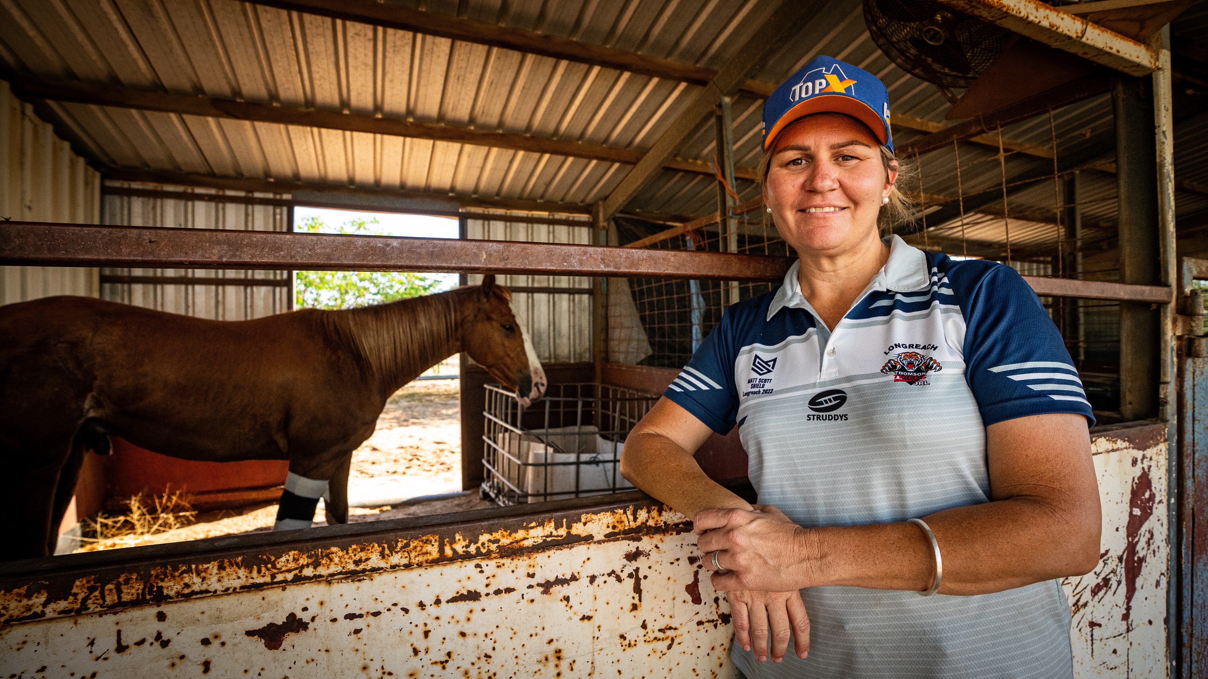 A woman standing in front of her horse