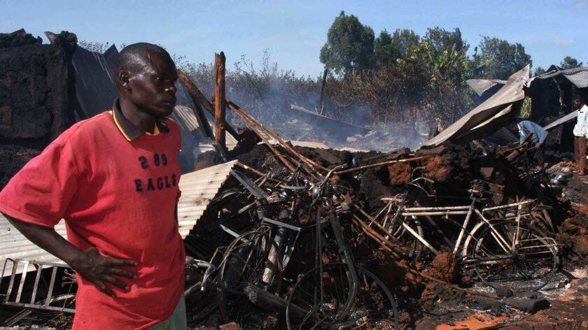 A Kenyan man stands beside the burnt remains of the Kenya Assemblies of God Church