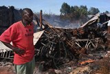 A Kenyan man stands beside the burnt remains of the Kenya Assemblies of God Church