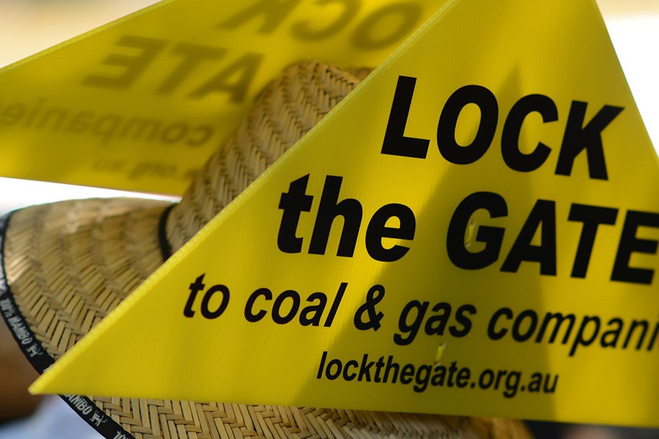 Anti-fracking protester wears a 'Lock the gate' sign (ABC: Tim Leslie)