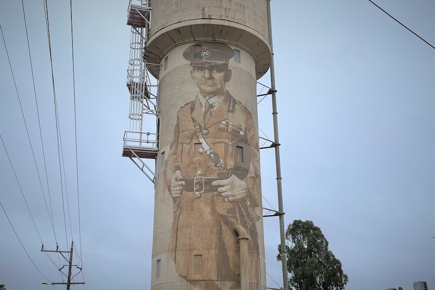 Water tower with man painted on it