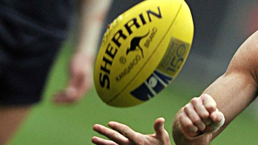 An AFL footballer handpasses during training