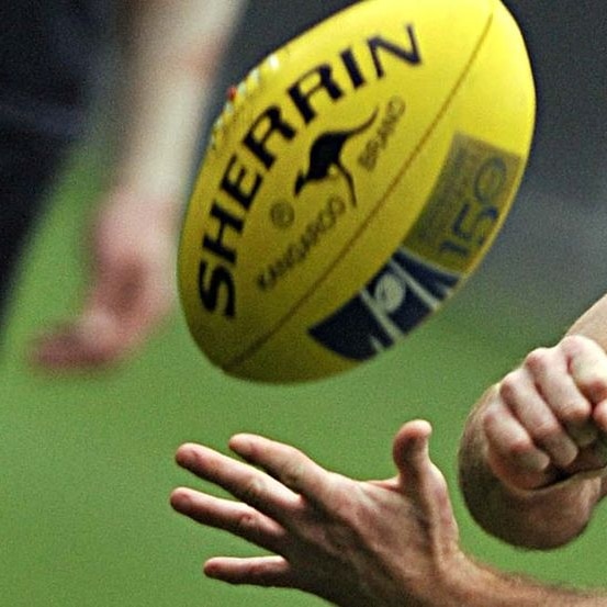 An AFL footballer handpasses during training