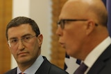 Julian Leeser looks at Peter Dutton at a press conference in the Liberal partyroom