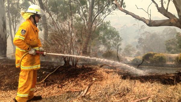 A firefighter hosing down a hotspot