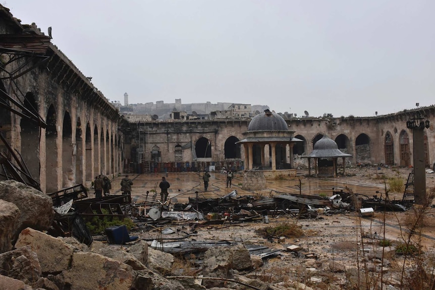 A wide photo of Syrian troops and pro-government gunmen inside the damaged Grand Umayyad mosque.