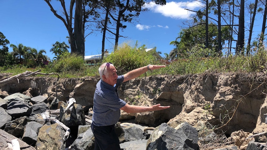 Toogoom resident Norm Hoffman showing where the rock wall has collapsed on the sea front.