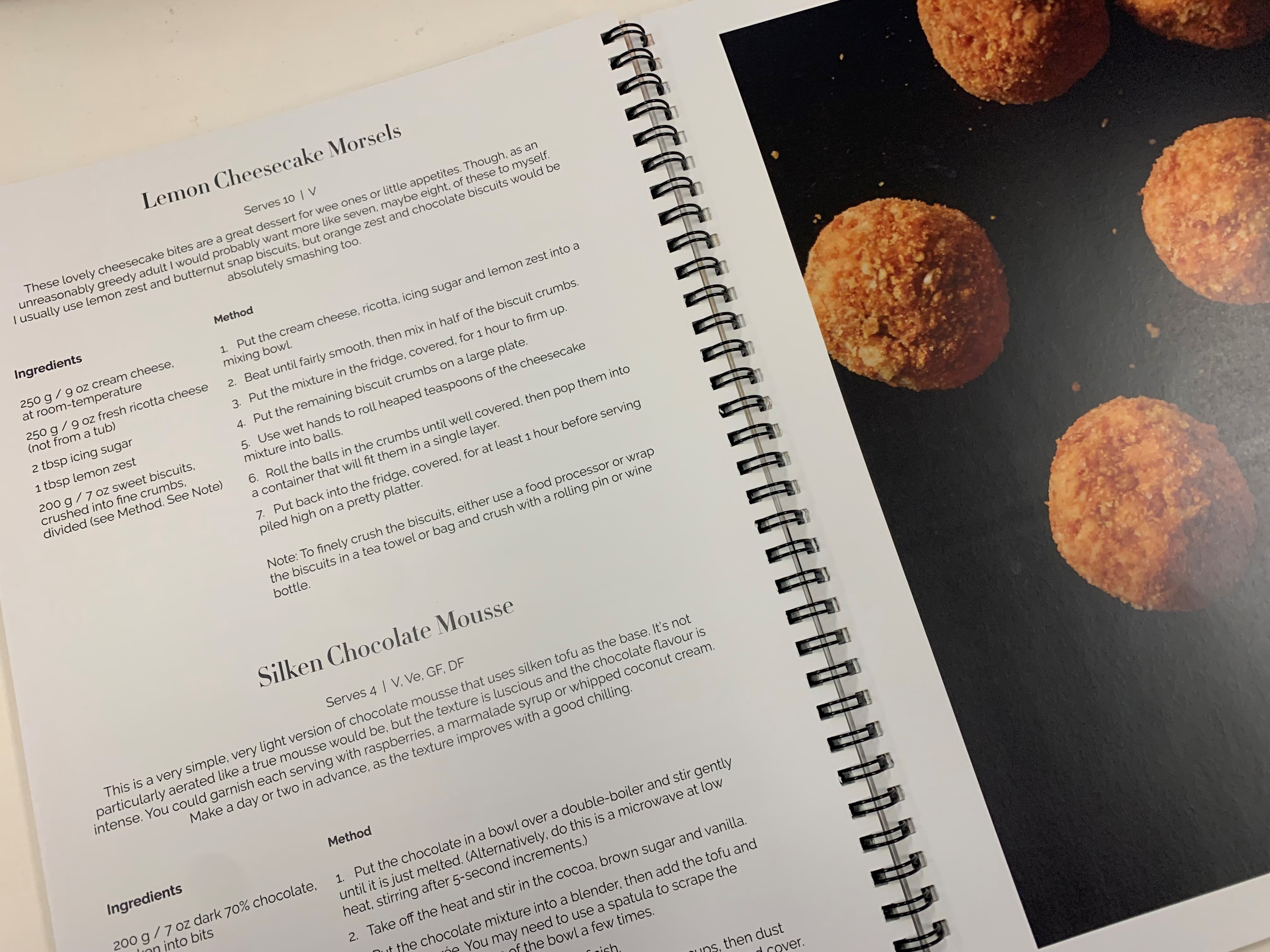 A recipe book open with a photo of and instructions for lemon cheesecake morsels.