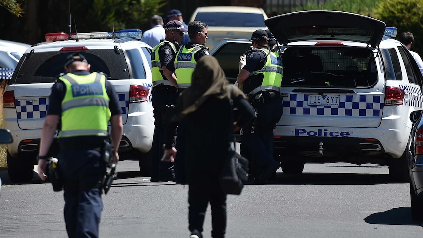 Police with woman at Meadow Heights following raids