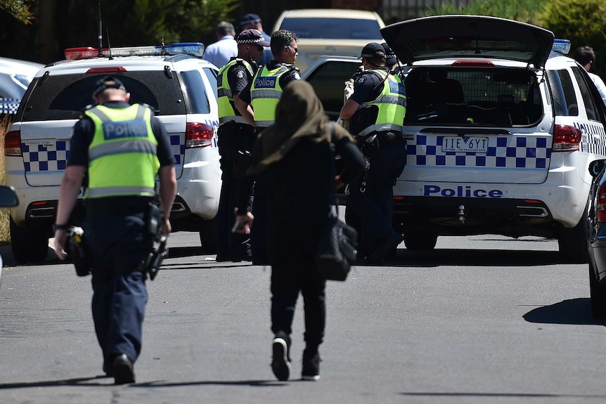 Police with woman at Meadow Heights following raids