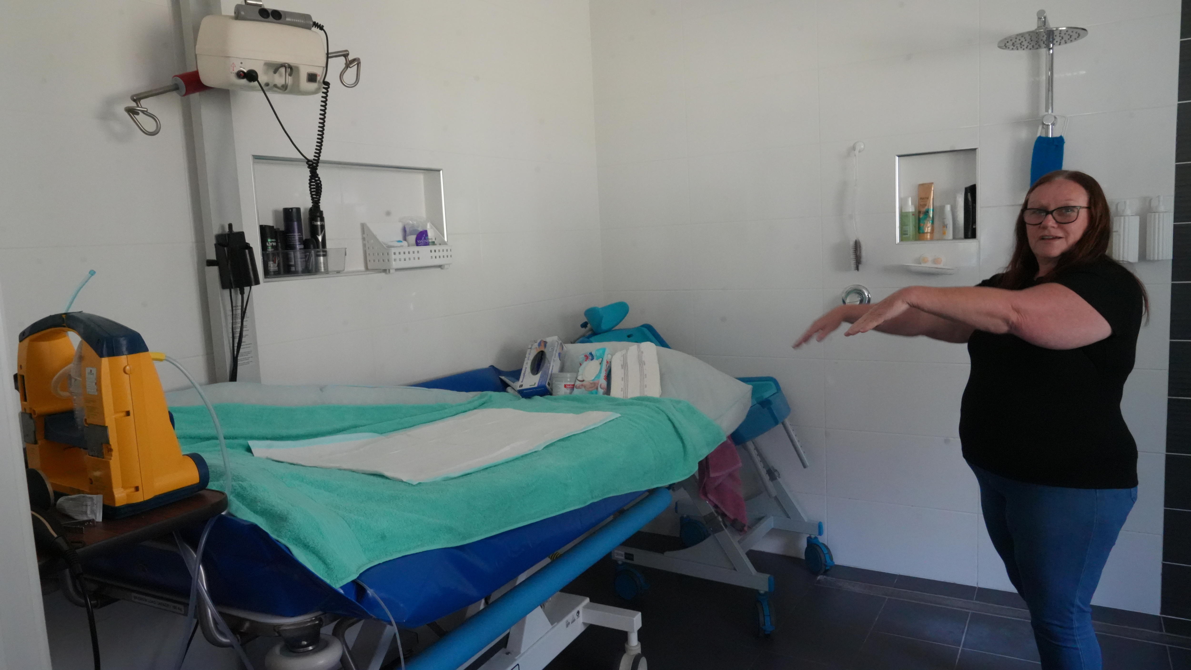Woman pointing to fittings in a bathroom