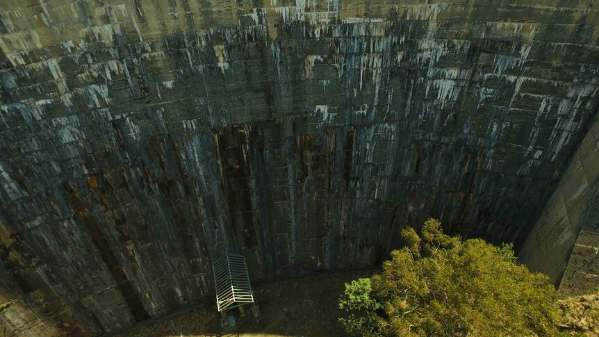 The steep wall of Tasmania's Ridgeway Dam, it is old and discoloured