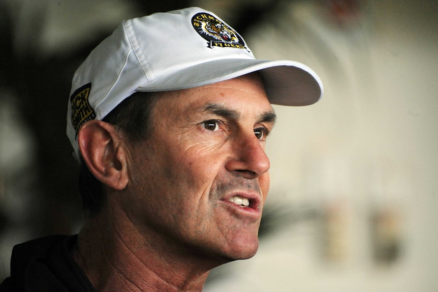 A cap wearing AFL coach speaks to the media.