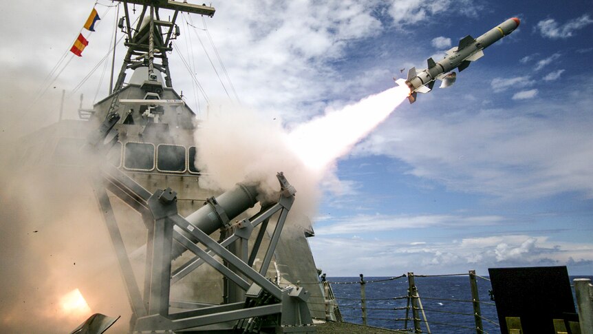 A missile blasts off from a ship-based launcher. 