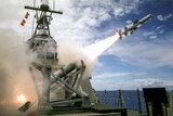 A missile blasts off from a ship-based launcher. 