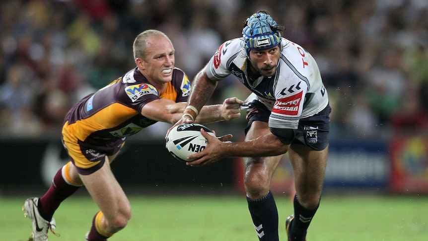 Cowboys half-back Johnathan Thurston gets past the defence of Broncos skipper Darren Lockyer