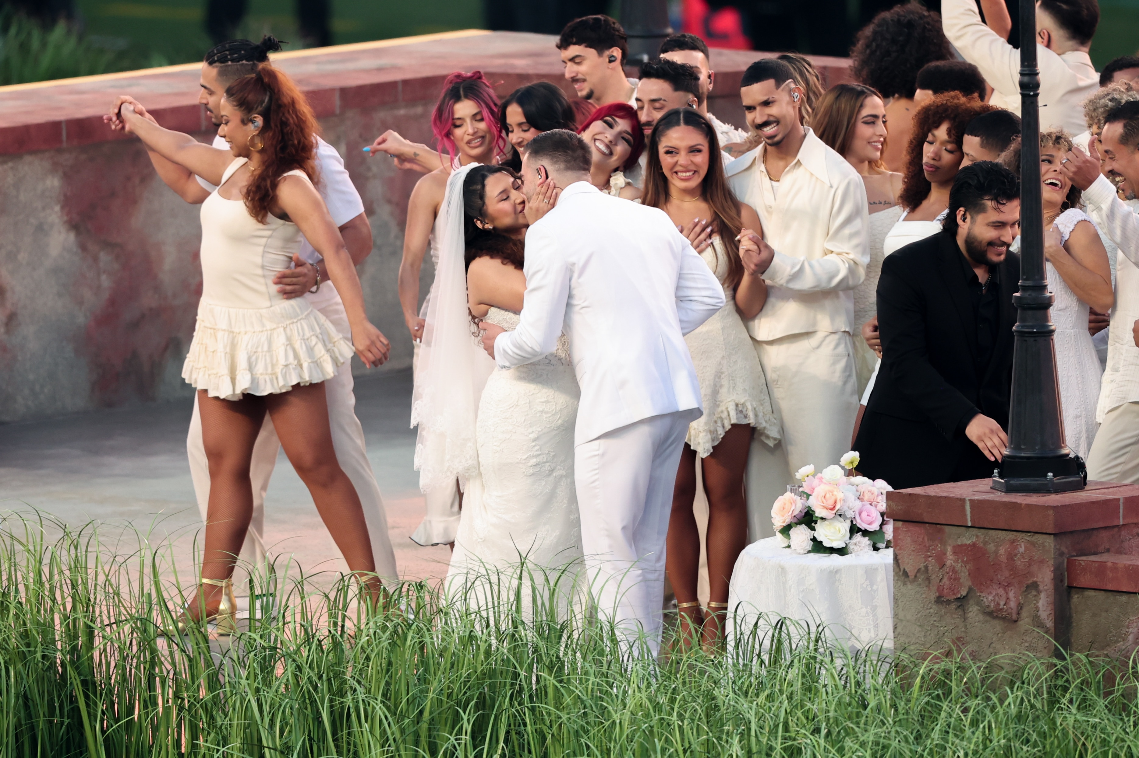 Bride and groom kiss during a wedding at a performance of the Super Bowl halftime show 