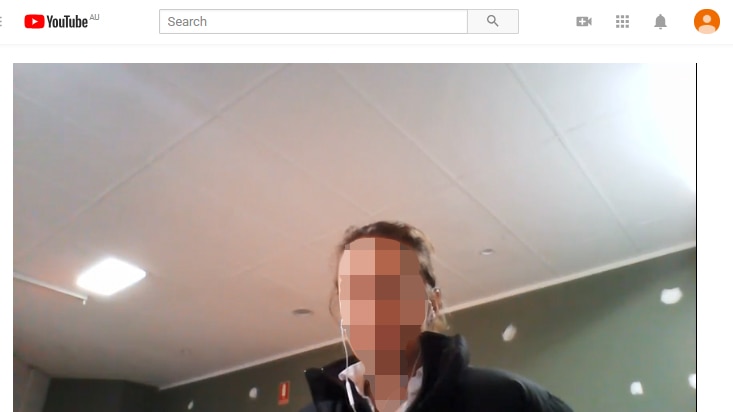 Screengrab of Youtube, with a woman, face pixelated, sitting in her home.