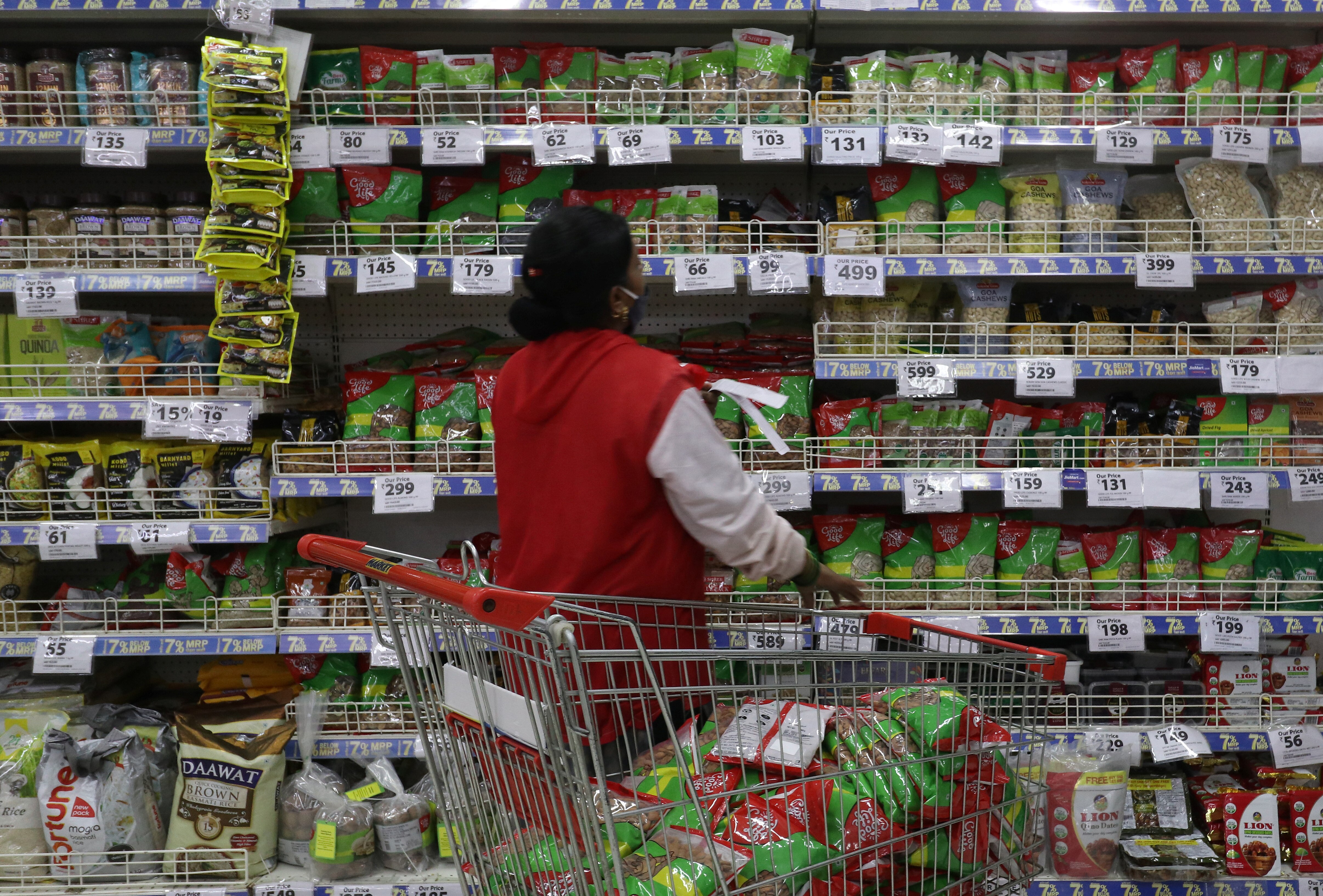 A worker in India rearranges goods in a store. 