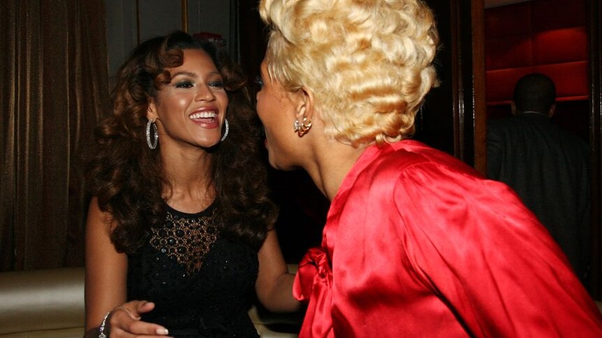 A photograph of Beyoncé and Kelis smiling at each other at a function