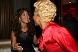 A photograph of Beyoncé and Kelis smiling at each other at a function