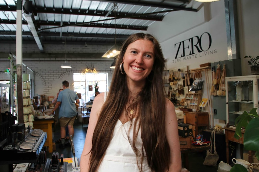 A woman stands in the middle of an industrial-looking retail store, surrounded by an assortment of homewares