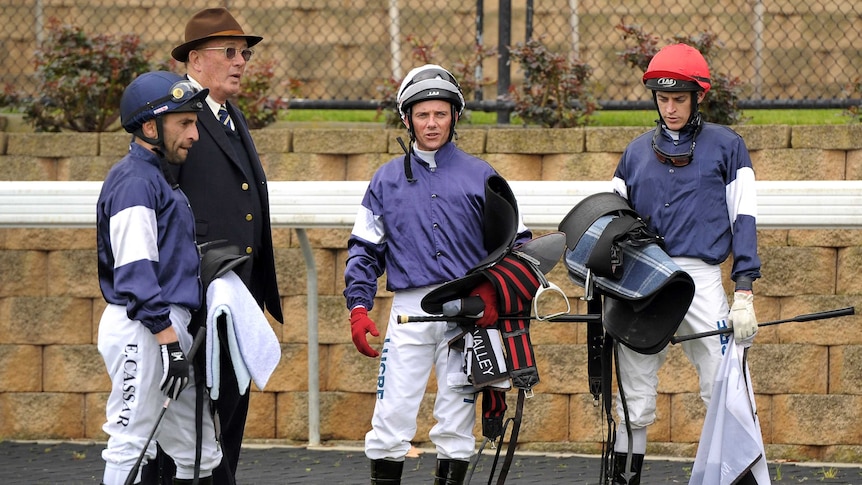 Lloyd Williams (2nd left) talks to his jockeys after his horses galloped at Moonee Valley in August.