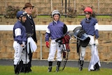 Lloyd Williams (2nd left) talks to his jockeys after his horses galloped at Moonee Valley in August.