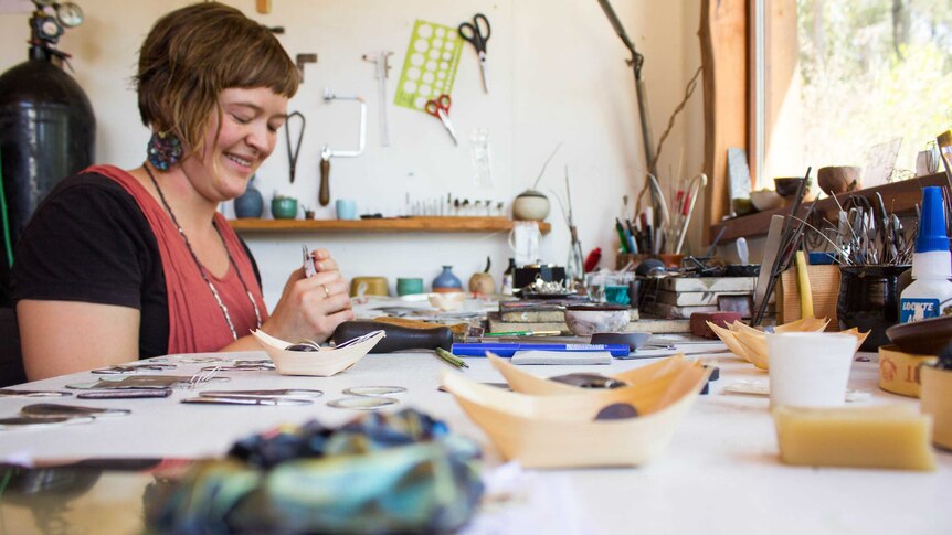Jill Hermans, working away at her desk in her studio in Clifton Creek.