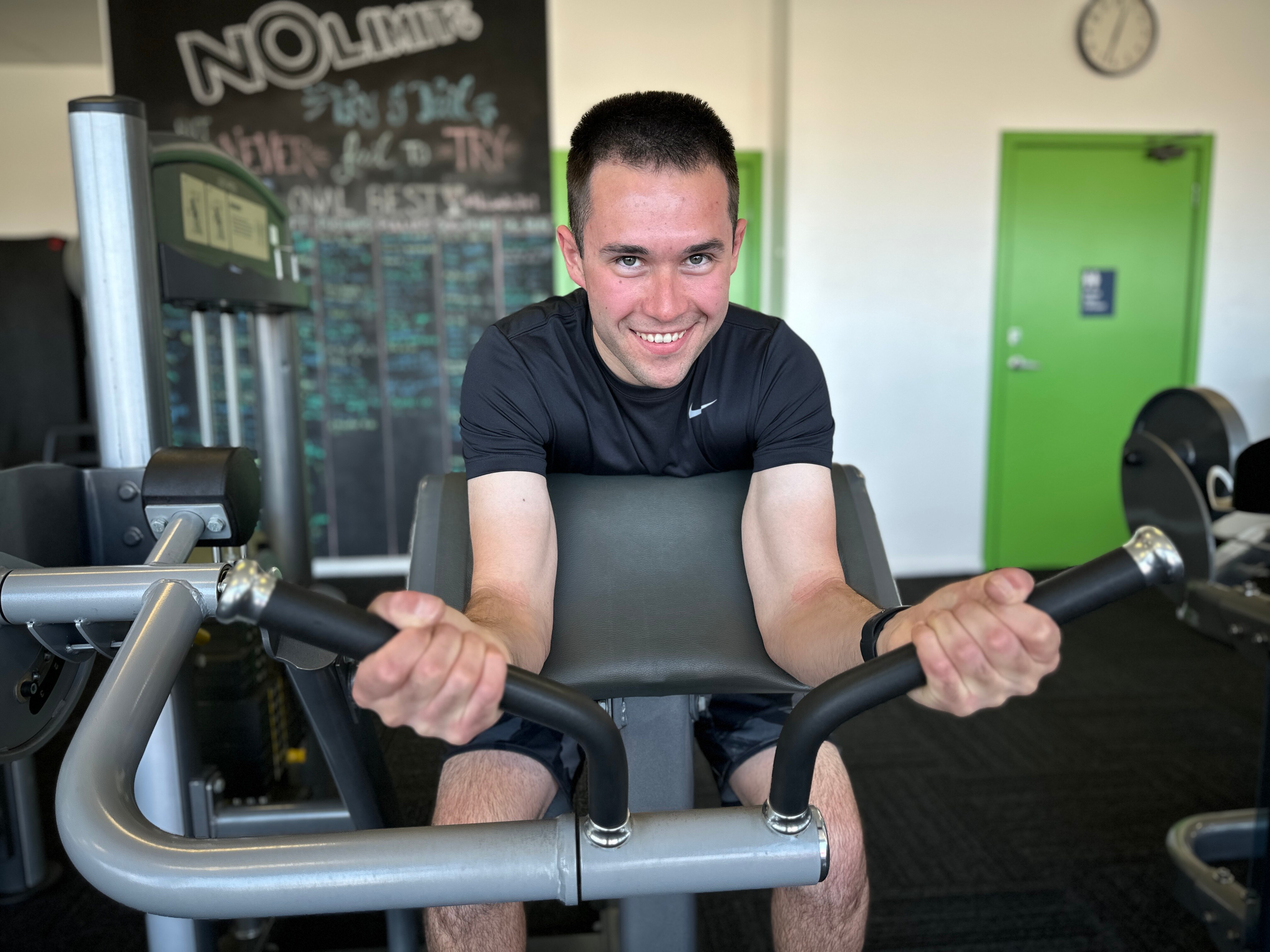 A man in a black t-shirt ride an exercise bicycle