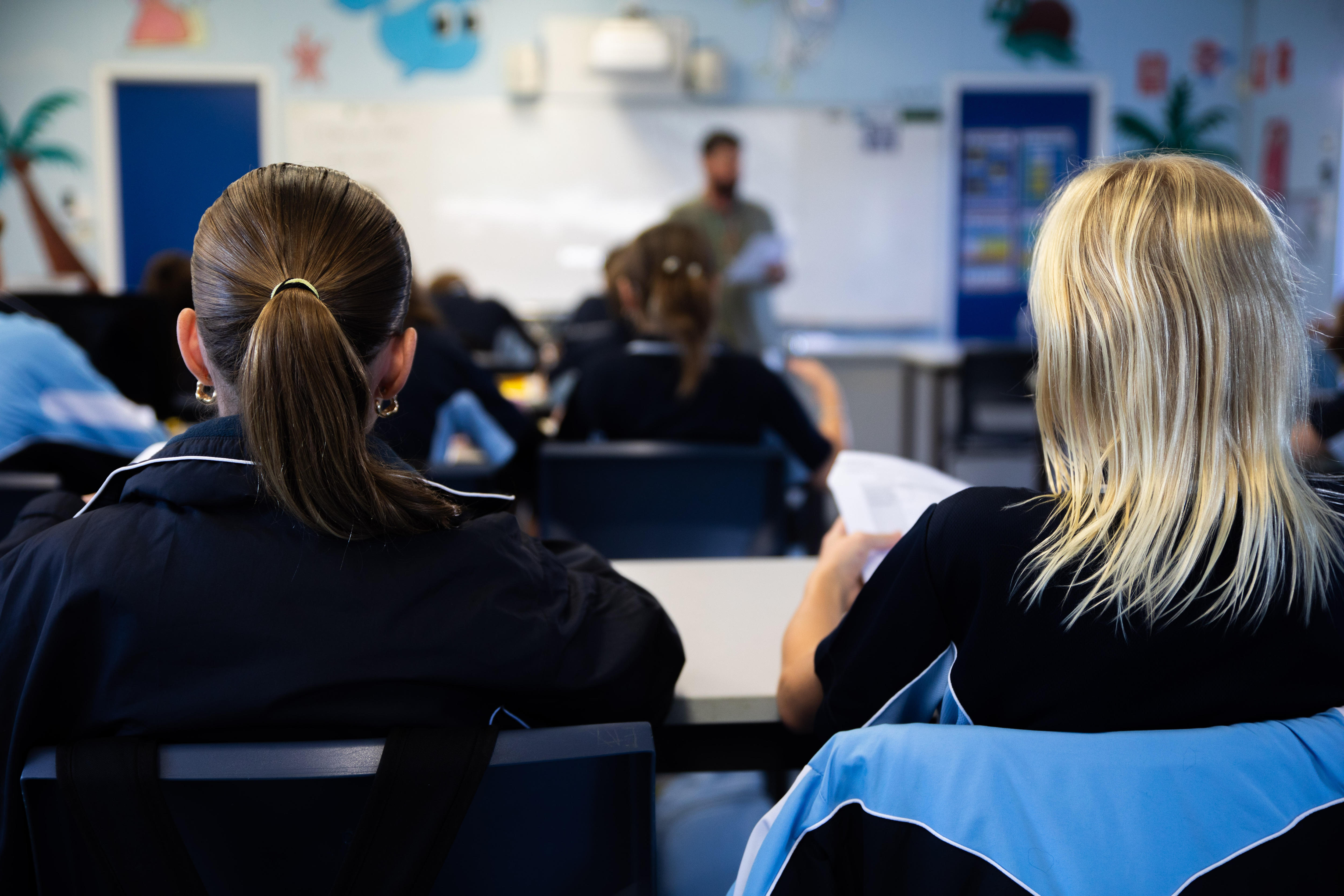 Two girls are having a class in a classroom. 