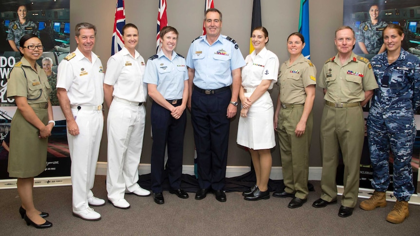 Group of male and female defence force members stand for group photo
