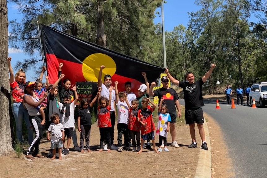 people in front of the aboriginal flag, protesting 