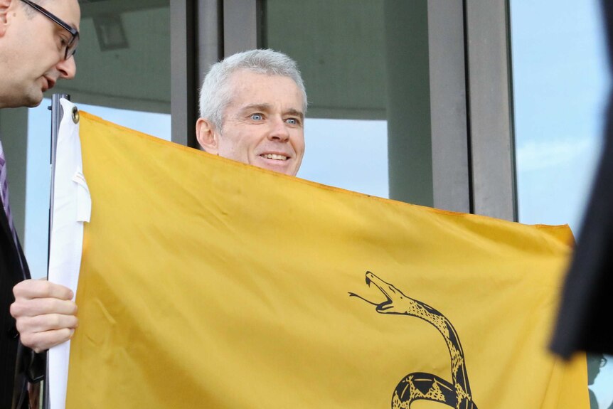 Malcolm Roberts holds Gadsden flag