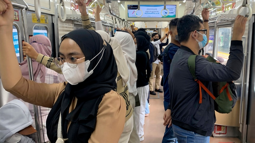 People travel on a train wearing face masks.