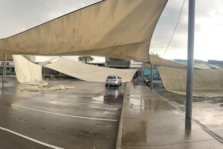 Shade sails in a car park hanging from wires after a storm
