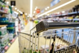 Close up of shopping trolley in supermarket aisle 