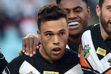 Tigers players celebrate a try against the Dragons