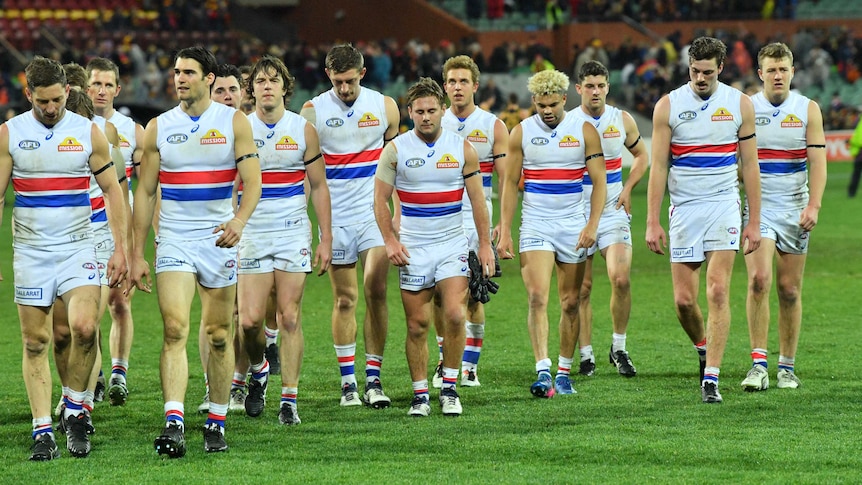 Western Bulldogs leave the field in low spirits during AFL loss to Adelaide Crows