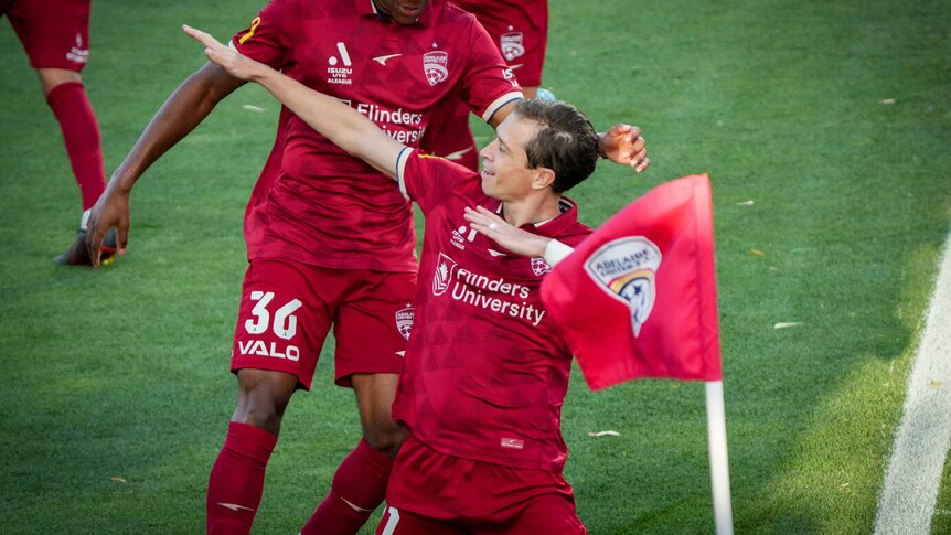 Two Adelaide United players celebrate.
