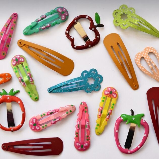 Photo of brightly coloured hair clips on a white bench